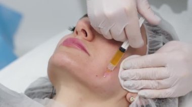 Top view medium close-up shot of platelet rich plasma face injections procedure | PRP Therapy in beauty salon | Young brown-haired female Caucasian patient.