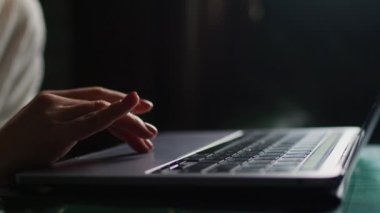 young woman sitting on sofa with laptop and looking at screen while typing a message, happy lady chatting on computer, browsing internet on social media, studying or working online at home
