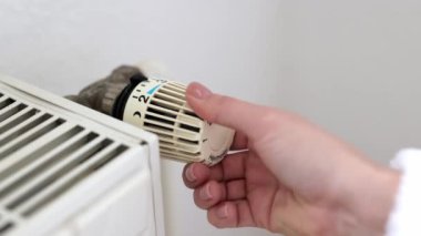 Erkek El Kontrol Sıcaklığı Beyaz Duvara Yakın Termostat Açık. Merkezi Buharlı Isıtma Sisteminde ısıyı kontrol edin. Kış konseptinde ev