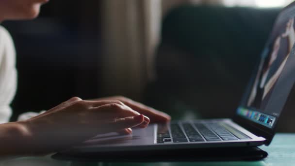 ノートパソコンでソファに座って画面を見ている若い女性は メッセージを入力しながら 幸せな女性は コンピュータ上でチャット ソーシャルメディア上でインターネットを閲覧 勉強や自宅でオンラインで働く — ストック動画
