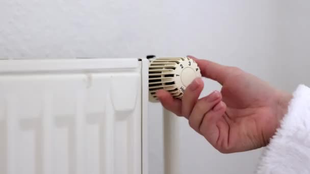 白い壁の近くのサーモスタットの男性の手制御温度 セントラル蒸気加熱システムで熱を制御します 冬のコンセプトの家 — ストック動画