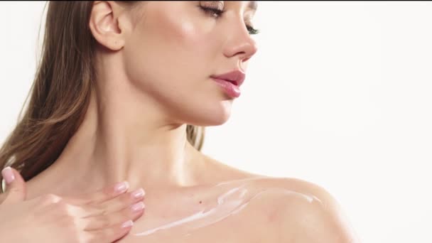 一个皮肤洁白的漂亮女人把润肤霜涂在她的皮肤上 护肤概念 化妆品和护肤广告 — 图库视频影像