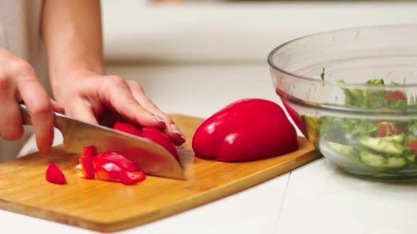 在室内的切菜板上放着菜刀 在厨房柜台上放着沙拉碗里的蔬菜片 家庭主妇在家里切蔬菜 做沙拉菜 — 图库视频影像