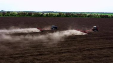 Tarlada traktörlerin işi, buğday ekmek. Bir çiftçi, traktörü bir drondan kontrol eder. Tarım teknolojisi, tarım ve sanayi konsepti.