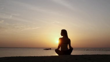 Dağlarda yoga seansı. Genç atletik kız güneş doğarken Cliffy dağlarında antrenman yapıyor, çeşitli yoga pozları veriyor - sağlıklı yaşam tarzı konsepti 4K görüntüler