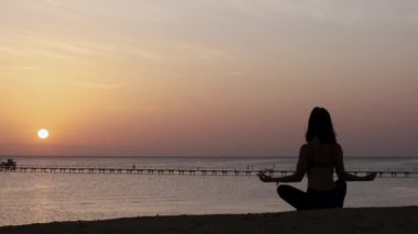 Dağlarda yoga seansı. Genç atletik kız güneş doğarken Cliffy dağlarında antrenman yapıyor, çeşitli yoga pozları veriyor - sağlıklı yaşam tarzı konsepti 4K görüntüler