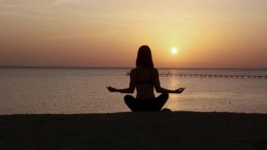 Dağlarda yoga seansı. Genç atletik kız güneş doğarken Cliffy dağlarında antrenman yapıyor, çeşitli yoga pozları veriyor - sağlıklı yaşam tarzı konsepti 4K görüntüler