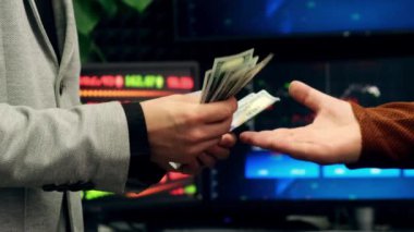 Elden ele para transferi. Bir iş adamının yakın plan çekimi hisse senedi üzerinden para veriyor. Başarılı bir anlaşma konsepti. Para transferi kavramı.