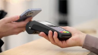 Elektronik ödeme makinesinden ya da kart okuyucudan cep telefonuyla satın alma. Oteldeki parasız erkek müşterinin cüzdanında e-para. Mağaza çalışanının yakın çekimde pos-terminal 'i. Kahve dükkanından bir masa al.