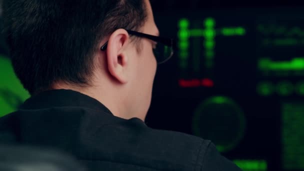 コンピュータのセキュリティを破ろうとしているハッカープログラマー 複数のディスプレイを持つ職場に座っているプログラムコードを書く男性プログラマ オフィスワーク — ストック動画