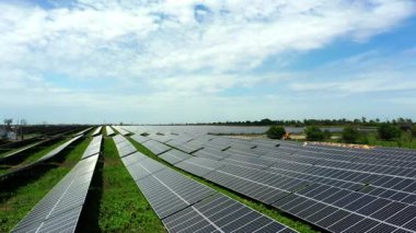 Amazing bird's eye view of solar panels standing in a row in the fields, green energy, landscape, electricity, ecology, innovation, nature, environment, slow motion.  