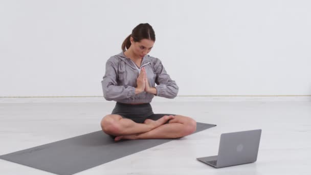 年轻健康的欧洲女性记录视频博客坐在瑜伽工作室的垫子上 瑜伽教练与订户交谈并解释练习 体育博客的概念 — 图库视频影像