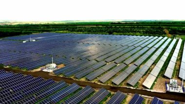 Aerial view of Solar Panels Farm (solar cell) with sunlight. Drone flight over solar panels field, renewable green alternative energy concept.