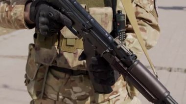 Asker eli tüfeği şarj ediyor. Saldırı tüfeği şarj ediliyor. Makineli tüfeğe yaklaşın. Asker silahını dolduruyor.