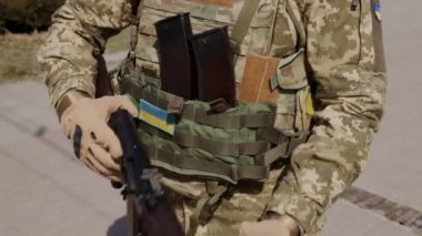 Asker eli Kalaşnikof tüfeğini şarj ediyor. Saldırı tüfeği Kalaşnikov saldırıyor. Makineli tüfeğe yaklaşın. Asker silahını dolduruyor.