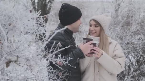 恋爱中的情侣在冬雪覆盖的森林里喝着热咖啡 彼此享受着4K — 图库视频影像