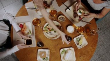 Bir grup insan kapalı bir masada brunch yapıyor.