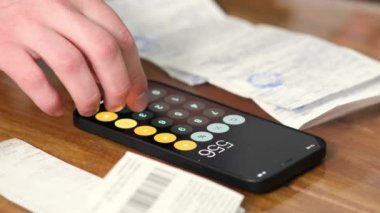 Summary and analysis of expenses and income for goods and services and salary. A person calculates utility bills and receipts using a smartphone calculator. A man counts money in cash dollars, euros.