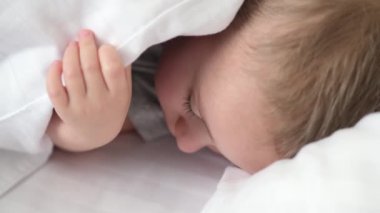 Huzurlu bebek odadaki yatakta uyuyor. Yumuşak odaklanma. Uyuyan bebek konsepti. Çocuk evde uyuyor..