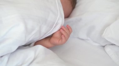 Huzurlu bebek odadaki yatakta uyuyor. Yumuşak odaklanma. Uyuyan bebek konsepti. Çocuk evde uyuyor..