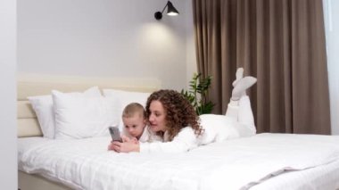 Anne ve 2 yaşındaki küçük oğlu yatağa uzanmış, cep telefonuna bakıyor, gülüyor, çizgi film izliyor, video görüşmeleri yapıyor, internette eğleniyorlar. İki nesildir aile yeni uygulama kullanıyor 