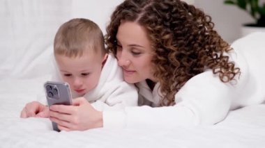 Anne ve 2 yaşındaki küçük oğlu yatağa uzanmış, cep telefonuna bakıyor, gülüyor, çizgi film izliyor, video görüşmeleri yapıyor, internette eğleniyorlar. İki nesildir aile yeni uygulama kullanıyor