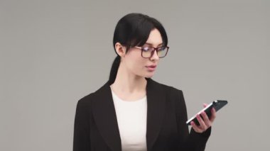 Kredi ve kredi konsepti. Avro parası ve akıllı telefonu elinde tutan gülümseyen Avrupalı genç bir kadın. Kamerada mutlu, arka planda hafif