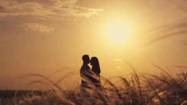 Aşık çift gün batımında romantik anlar yaşıyor. Yaz tatilindeki genç aşıklar. Aşk ya da balayı kavramı. Gün batımında siluet öpücüğü.