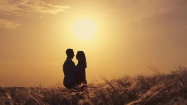 Aşık çift gün batımında romantik anlar yaşıyor. Yaz tatilindeki genç aşıklar. Aşk ya da balayı kavramı. Gün batımında siluet öpücüğü.