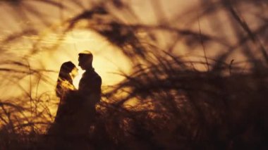 Aşık çift gün batımında romantik anlar yaşıyor. Yaz tatilindeki genç aşıklar. Aşk ya da balayı kavramı. Gün batımında siluet öpücüğü.