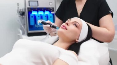 Kozmetoloji kliniğindeki güzel kadın hastalara hidro soyma işlemi yapan tıbbi eldivenler giyen profesyonel bir dermatolog. Yüz tedavisini kapat.