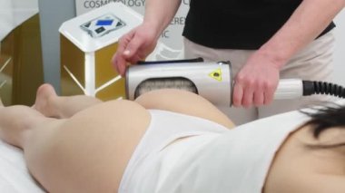 Correction of the figure and body shape. Close-up of the device massaging the buttocks and legs of a young woman. The concept of beauty and body care. The cosmetologist uses the device for endospheric