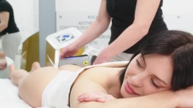 Correction of the figure and body shape. Close-up of the device massaging the buttocks and legs of a young woman. The concept of beauty and body care. The cosmetologist uses the device for endospheric