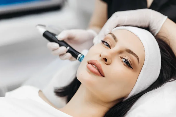 stock image Pleasant relaxation. Beautiful young woman closing her eyes while having a hydrafacial procedure