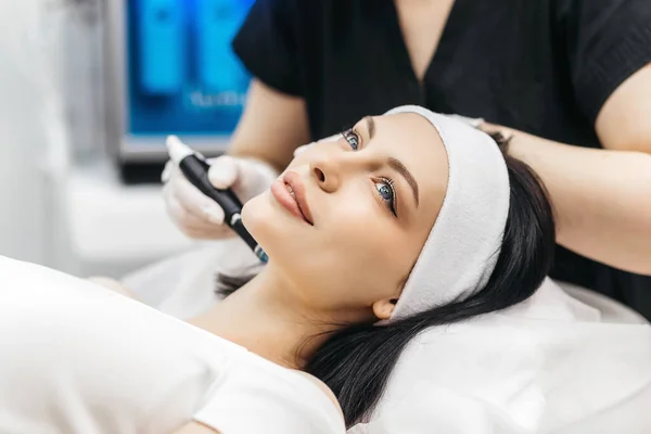 Hydropeeling beauty procedure, cleaning face, Clean Skin. Woman patient in cosmetology clinic, doctor performing beauty procedure in cosmetology clinic, beautician cleaning patient's face
