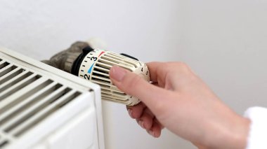 Erkek El Kontrol Sıcaklığı Beyaz Duvara Yakın Termostat Açık. Merkezi Buharlı Isıtma Sisteminde ısıyı kontrol edin. Kış konseptinde ev