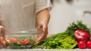 Açık havada sebze salatası yapıyorum. Taze çiğ sebzelerden salata yapmak - domates, salatalık, yeşillik, biber, soğan, zeytinyağı. Açık havada.