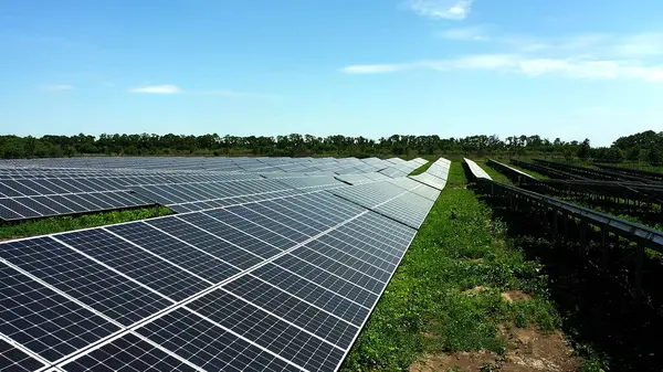 Close-up of modern photovoltaic solar battery. Rows of sustainable energy solar panels installed on farmland meadow rural field. Concept for ecology.
