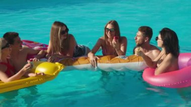 Güneşli bir yaz gününde bir grup güzel genç arkadaş havuzda eğleniyor. Rahatlama, dinlenme ve keyif kavramı