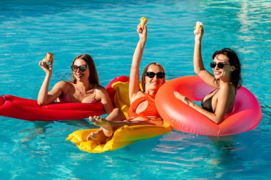 Yakın plan mutlu genç kadınlar havuz partisinde havada süzülüyor - yaz tatilinde eğleniyorlar - seyahat, arkadaşlık, gençlik ve tropik konseptler