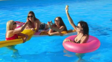 Bir grup güzel genç kadın, güneşli bir yaz gününde dondurma yiyor ve havuzda eğleniyorlar. Rahatlama, dinlenme ve keyif kavramı