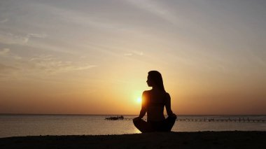 Gün batımında denizin altında güçlü, kendine güvenen, güzel bir kadın.