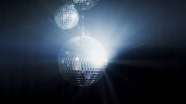 Renkli bir disko ayna topları bir gece kulübünün arka fonunu aydınlatır. Parti disko topunu aydınlatıyor..