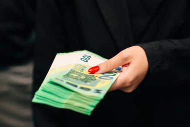 Şık takım elbiseli genç bayan iş kadını elinde iyi miktarda avroyla şık giyinmiş. İş ve gelir kavramı