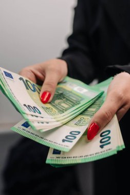 Şık takım elbiseli genç bayan iş kadını elinde iyi miktarda avroyla şık giyinmiş. İş ve gelir kavramı