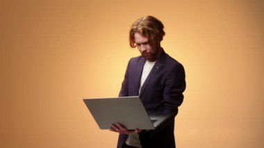 Dizüstü bilgisayarı olan karizmatik iş adamı daktilo ediyor ve parmak gösteriyor. Çevrimiçi iş kavramı