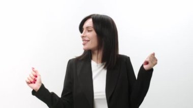 İlham verici bir ifadeyle dans eden genç ve güzel bir kadın. Aktif genç bir kadın hafif bir arka planda eğleniyor..