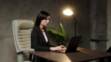 Bilgisayarda çalışan Asyalı kadın. Modern ofiste dizüstü bilgisayarla çalışan bir iş kadını. İşi teknolojik seviyeye nasıl çıkaracağımı düşünüyorum..