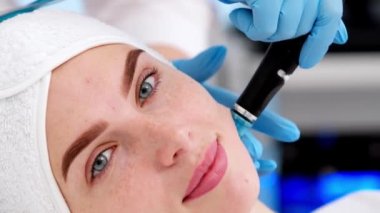 Kozmetoloji kliniğinde hidra-yüz ameliyatı yapan profesyonel bir kadın kozmetik uzmanı. Doktor Hydra elektrikli süpürge kullanıyor. Yenilenme ve kozmetoloji kavramı