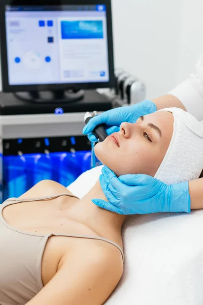 Kozmetoloji kliniğinde hidra-yüz ameliyatı yapan profesyonel bir kadın kozmetik uzmanı. Doktor Hydra elektrikli süpürge kullanıyor. Yenilenme ve kozmetoloji kavramı